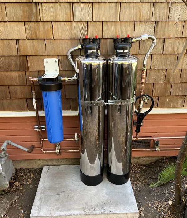 Water softener system installed in a residential utility room | Water Softeners